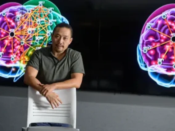 Associate Professor Rui Chang standing in front of monitor