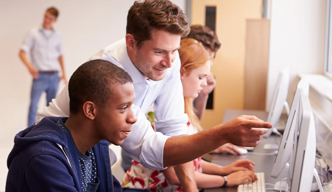 Teacher helping student at computer