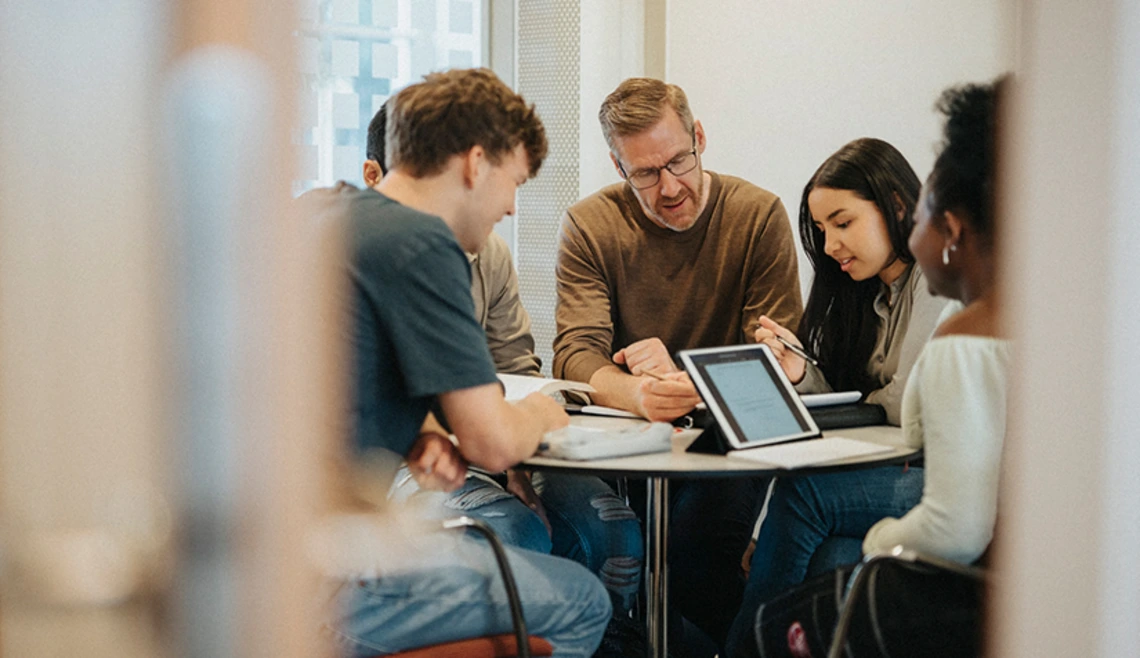 Teacher working closely with group of students